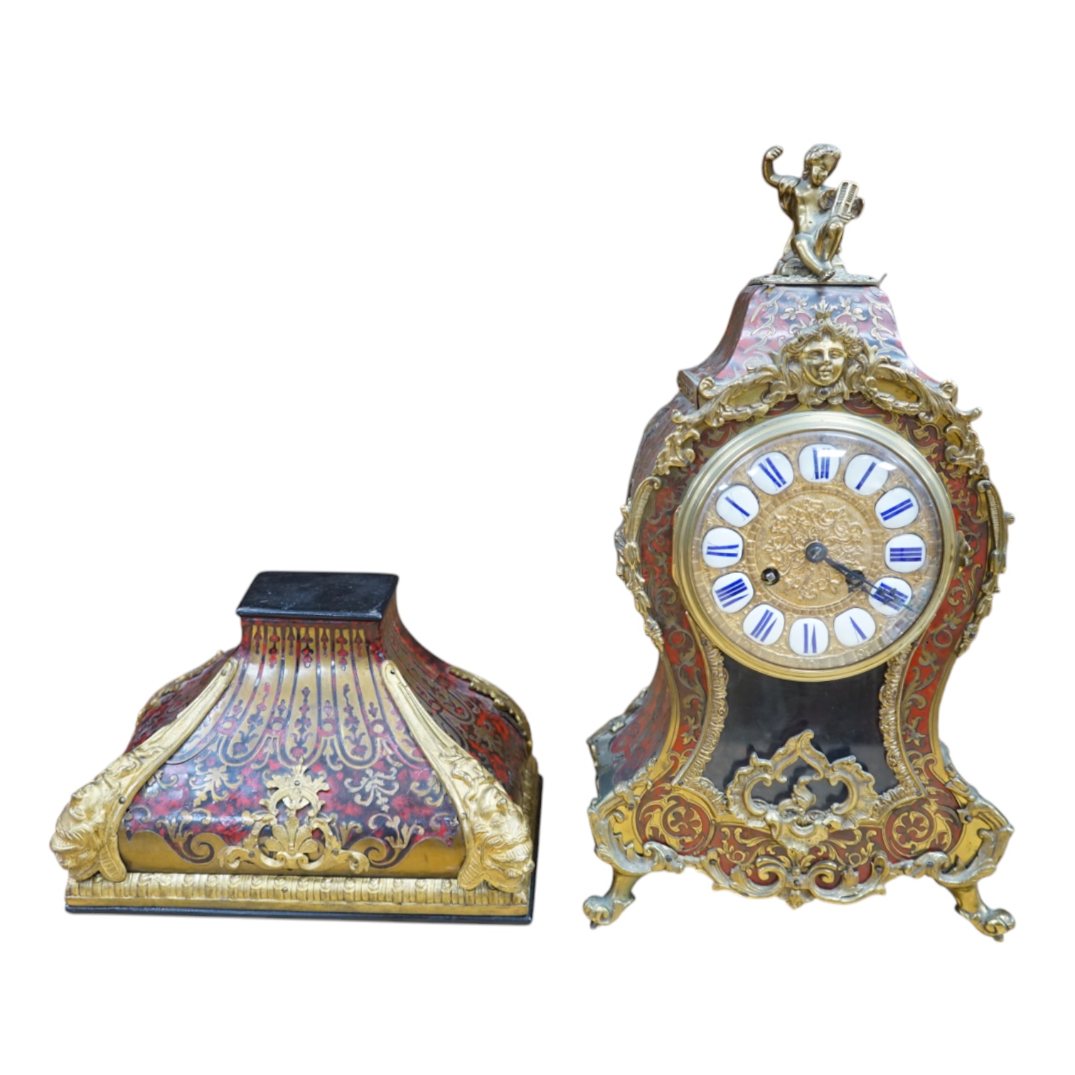 A French scarlet Boulle clock, and original bracket, the waisted case with glass front enclosing boulle interior and sunburst pendulum, c. 1860, clock 42cm high. Condition - fair, untested